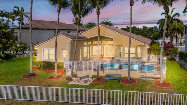 4506 SW 186th Way, Miramar, FL 33029 - back of property at dusk with a patio area, stucco siding, and a tiled roof