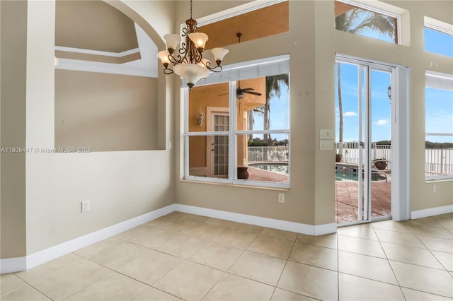 4506 SW 186th Way, Miramar, FL 33029 - empty room with a chandelier, tile patterned floors, arched walkways, baseboards, and crown molding