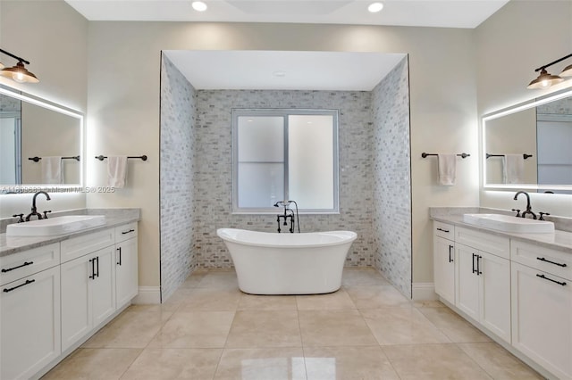 15122 SW 34th St, Davie, FL 33331 - full bathroom with two vanities, a freestanding tub, tile patterned floors, baseboards, and recessed lighting