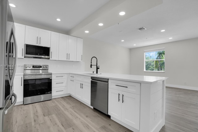 4123 Parkside Dr, Jupiter, FL 33458 - kitchen with appliances with stainless steel finishes, a sink, a peninsula, light wood finished floors, and recessed lighting