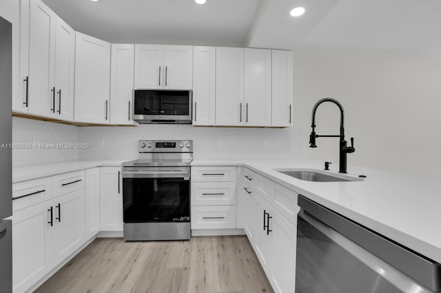 4123 Parkside Dr, Jupiter, FL 33458 - kitchen featuring appliances with stainless steel finishes, a sink, recessed lighting, light wood-style flooring, and light countertops