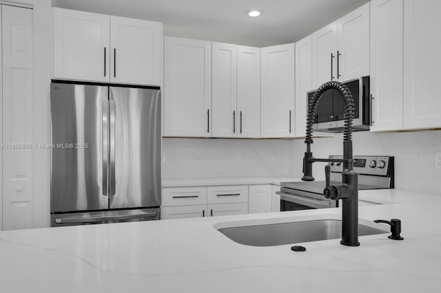 4123 Parkside Dr, Jupiter, FL 33458 - kitchen with stainless steel appliances, white cabinets, backsplash, recessed lighting, and light stone countertops
