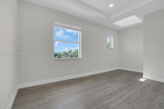 4123 Parkside Dr, Jupiter, FL 33458 - empty room with a skylight, wood finished floors, recessed lighting, baseboards, and a tray ceiling