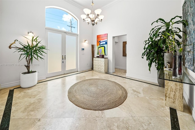 425 N Shore Dr, Miami Beach, FL 33141 - foyer entrance with ornamental molding, baseboards, a high ceiling, a chandelier, and inlaid floor details