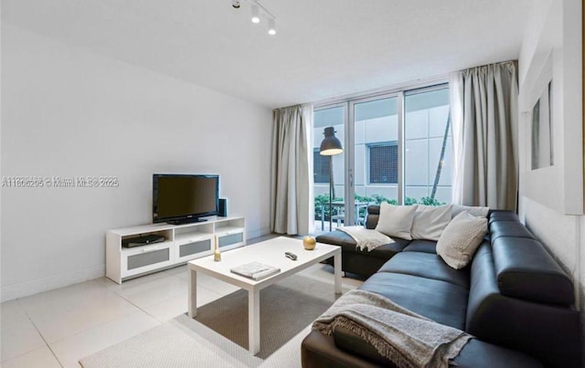 3901 S Ocean Dr Unit 1B, Hollywood, FL 33019 - living room featuring light tile patterned floors, baseboards, and a wall of windows