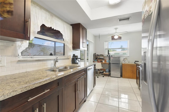5723 NW 69th Ave, Tamarac, FL 33321 - kitchen with stainless steel appliances, light tile patterned floors, tasteful backsplash, a sink, and light stone counters