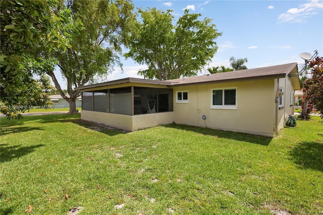 5723 NW 69th Ave, Tamarac, FL 33321 - rear view of house with a lawn, a sunroom, and stucco siding