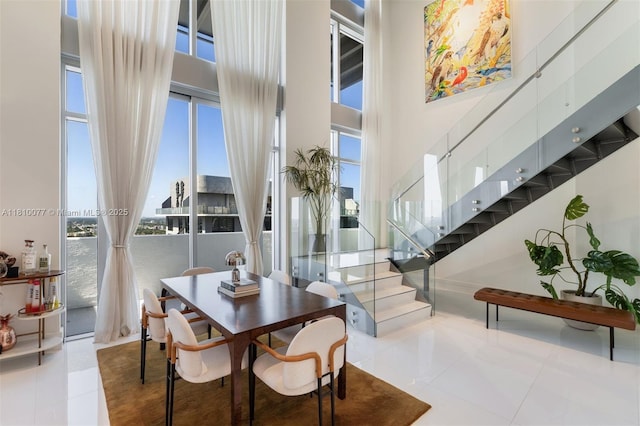 3301 NE 1st Ave Unit Ph7, Miami, FL 33137 - dining room featuring tile patterned floors, a towering ceiling, and stairs