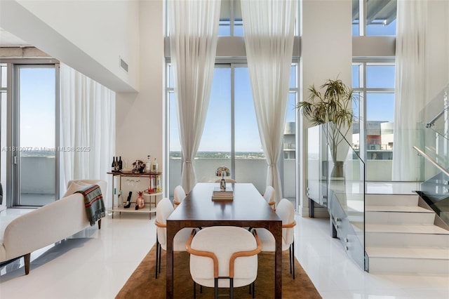 3301 NE 1st Ave Unit Ph7, Miami, FL 33137 - tiled dining area featuring plenty of natural light, a water view, a high ceiling, and stairs