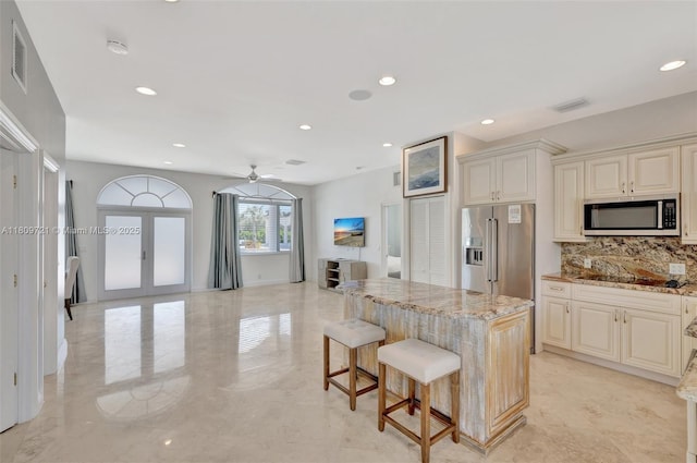 4610 SW 178th Ave, Southwest Ranches, FL 33331 - kitchen featuring stainless steel appliances, tasteful backsplash, light stone counters, a kitchen island, and recessed lighting