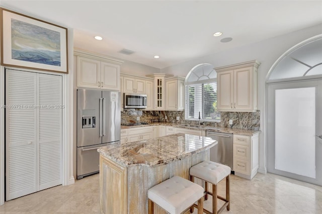 4610 SW 178th Ave, Southwest Ranches, FL 33331 - kitchen with appliances with stainless steel finishes, light stone counters, cream cabinets, a sink, and backsplash