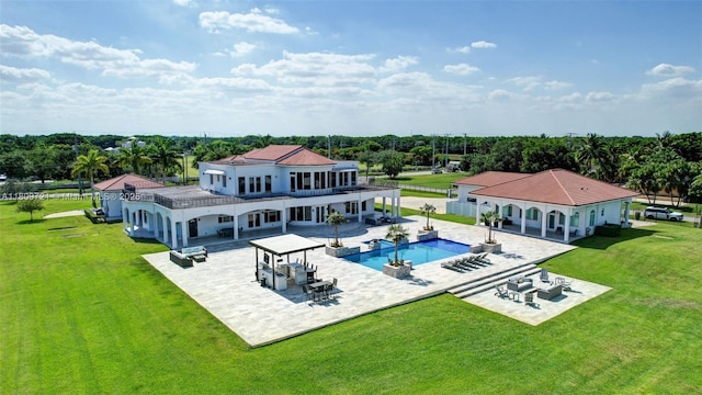 4610 SW 178th Ave, Southwest Ranches, FL 33331 - back of house featuring a patio area, a lawn, an outdoor pool, and a balcony