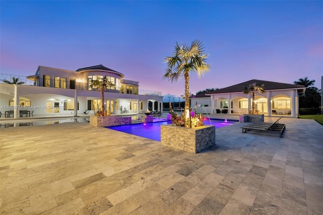 4610 SW 178th Ave, Southwest Ranches, FL 33331 - back of house at dusk with a patio, an outdoor pool, and stucco siding