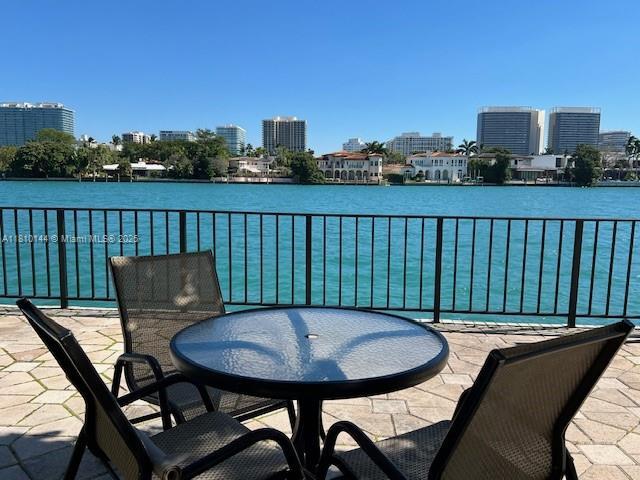 10101 E Bay Harbor Dr Unit 401, Bay Harbor Islands, FL 33154 - balcony featuring a view of skyline, a water view, and outdoor dining area