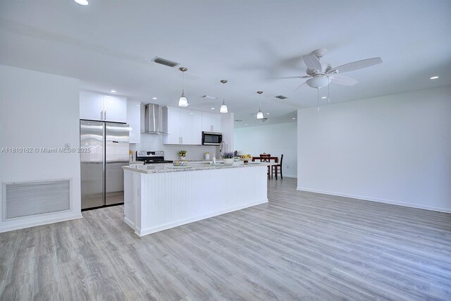 100 Honeysuckle Ln, Lake Placid, FL 33852 - kitchen featuring appliances with stainless steel finishes, wall chimney range hood, recessed lighting, white cabinets, and an island with sink