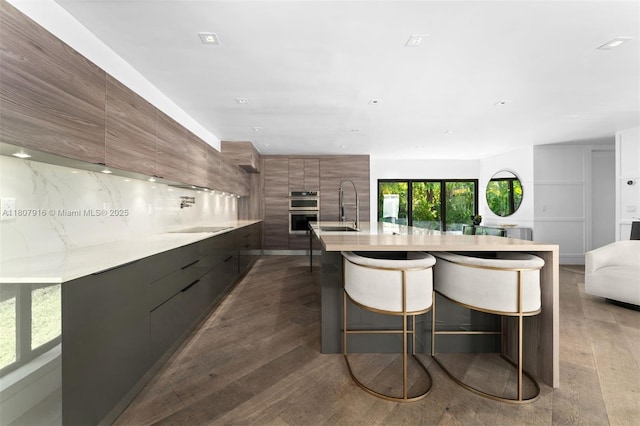 4250 Bay Point Rd, Miami, FL 33137 - kitchen featuring modern cabinets, a sink, light countertops, brown cabinets, and recessed lighting