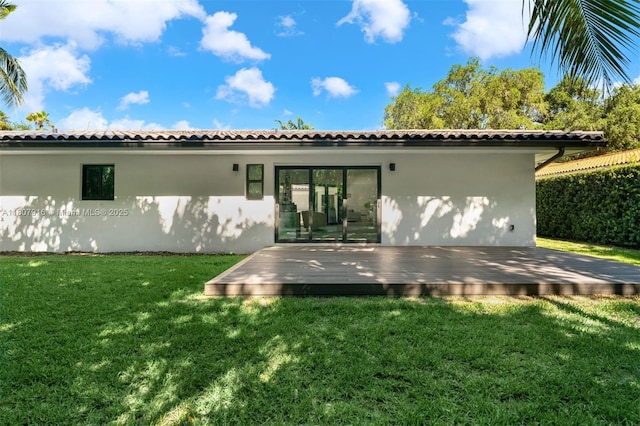 4250 Bay Point Rd, Miami, FL 33137 - rear view of property featuring stucco siding, a deck, and a lawn