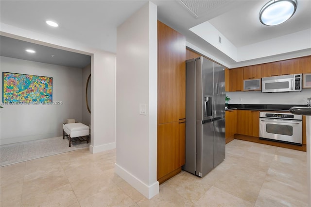 14951 Royal Oaks Ln Unit 901, North Miami, FL 33181 - kitchen with appliances with stainless steel finishes, brown cabinets, dark countertops, baseboards, and recessed lighting