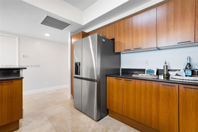 14951 Royal Oaks Ln Unit 901, North Miami, FL 33181 - kitchen featuring stainless steel fridge, dark countertops, brown cabinetry, baseboards, and modern cabinets