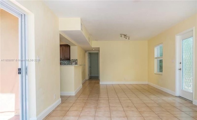 1215-1217 NE 16th Ave, Fort Lauderdale, FL 33304 - spare room with light tile patterned floors, rail lighting, and healthy amount of natural light