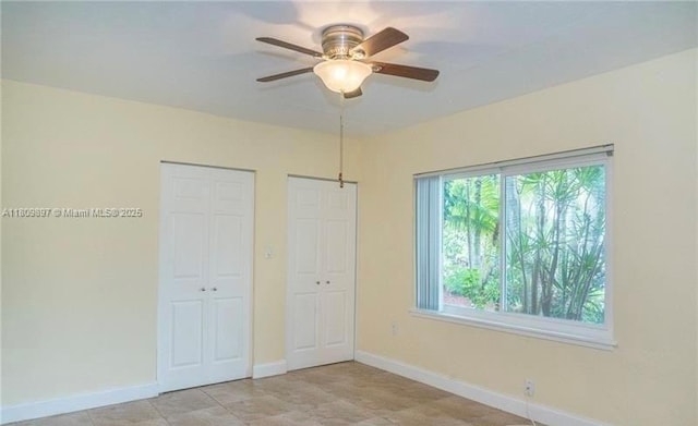 1215-1217 NE 16th Ave, Fort Lauderdale, FL 33304 - unfurnished bedroom featuring multiple closets, baseboards, and a ceiling fan