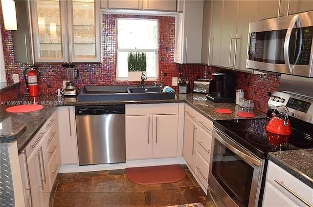 1215-1217 NE 16th Ave, Fort Lauderdale, FL 33304 - kitchen featuring appliances with stainless steel finishes, backsplash, white cabinetry, and glass insert cabinets