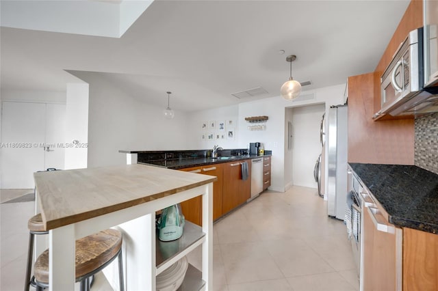 3131 NE 188th St Unit 2-506, Aventura, FL 33180 - kitchen featuring a sink, appliances with stainless steel finishes, pendant lighting, brown cabinets, and light tile patterned flooring