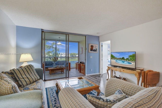 14671 Bonaire Blvd Unit 510, Delray Beach, FL 33446 - living area featuring wood finished floors, a textured ceiling, baseboards, and expansive windows