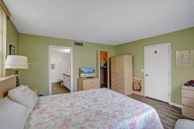 14671 Bonaire Blvd Unit 510, Delray Beach, FL 33446 - bedroom with wood finished floors, a textured ceiling, ensuite bathroom, baseboards, and a walk in closet