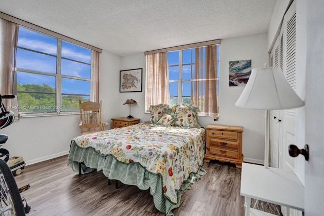 14671 Bonaire Blvd Unit 510, Delray Beach, FL 33446 - bedroom with a textured ceiling, baseboards, multiple windows, and wood finished floors