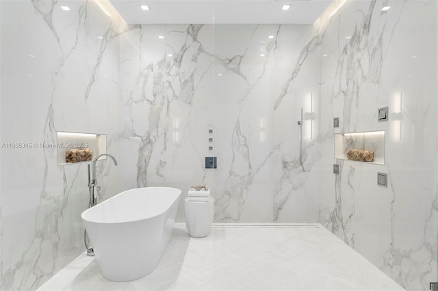 11001 SW 65th Ave, Pinecrest, FL 33156 - full bathroom with stone wall, a freestanding bath, a marble finish shower, recessed lighting, and tile walls