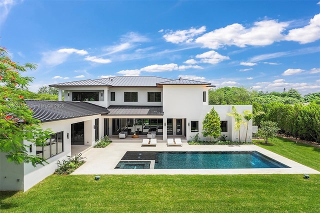 11001 SW 65th Ave, Pinecrest, FL 33156 - rear view of property featuring a standing seam roof, an outdoor hangout area, stucco siding, a lawn, and a patio