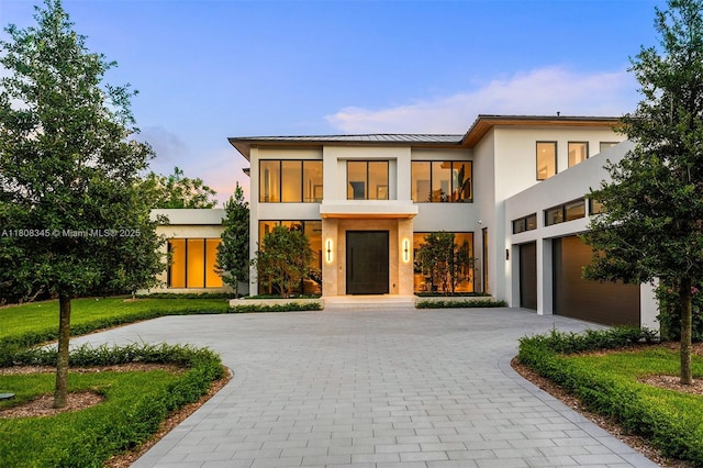 11001 SW 65th Ave, Pinecrest, FL 33156 - contemporary house featuring stucco siding, curved driveway, a standing seam roof, a balcony, and a metal roof