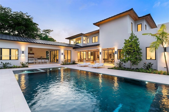 11001 SW 65th Ave, Pinecrest, FL 33156 - back of property featuring a patio area, a standing seam roof, stucco siding, and metal roof