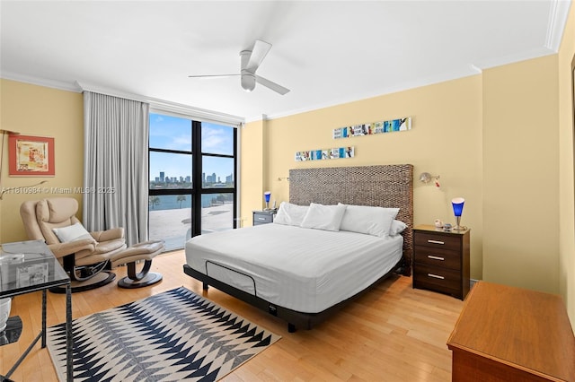 9 Island Ave Unit 505, Miami Beach, FL 33139 - bedroom with crown molding, light wood finished floors, a wall of windows, a ceiling fan, and a view of city