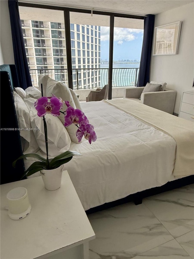 555 NE 15th St Unit 15G, Miami, FL 33132 - bedroom featuring marble look tile flooring, access to outside, and a water view
