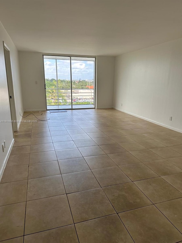 1830 Dixieanna St Unit 606, Hollywood, FL 33020 - unfurnished room featuring tile patterned flooring, a wall of windows, and baseboards