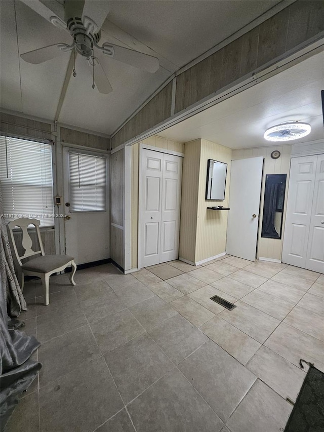 2848 W Marina Dr, Dania Beach, FL 33312 - foyer entrance with lofted ceiling, ceiling fan, light tile patterned floors, baseboards, and wooden walls
