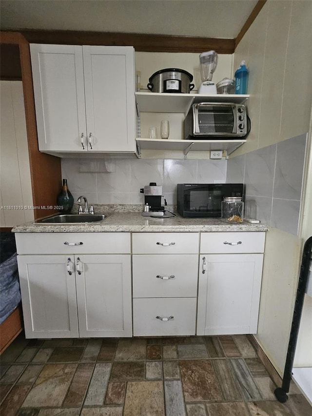 2848 W Marina Dr, Dania Beach, FL 33312 - kitchen featuring a sink, open shelves, white cabinetry, and black microwave