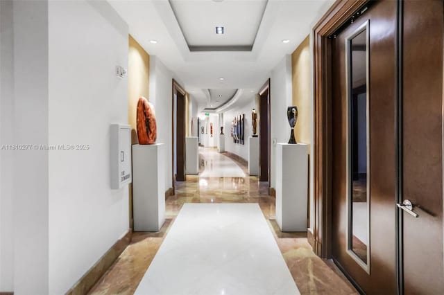 1 N Ocean Blvd Unit 508, Pompano Beach, FL 33062 - hallway featuring light marble finish floors, a tray ceiling, and baseboards