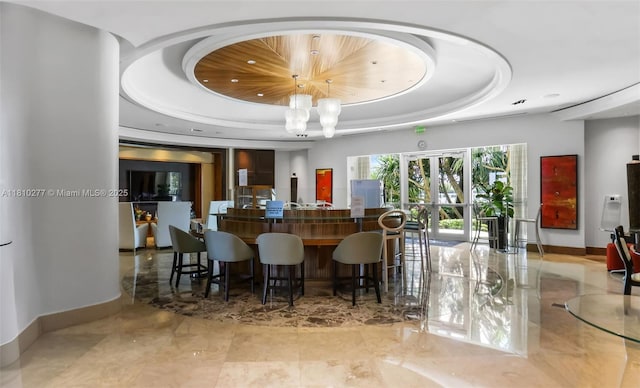 1 N Ocean Blvd Unit 508, Pompano Beach, FL 33062 - bar with a raised ceiling, baseboards, a chandelier, and pendant lighting