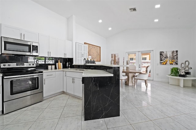 13236 SW 51st St, Miramar, FL 33027 - kitchen with appliances with stainless steel finishes, a peninsula, a sink, high vaulted ceiling, and decorative backsplash