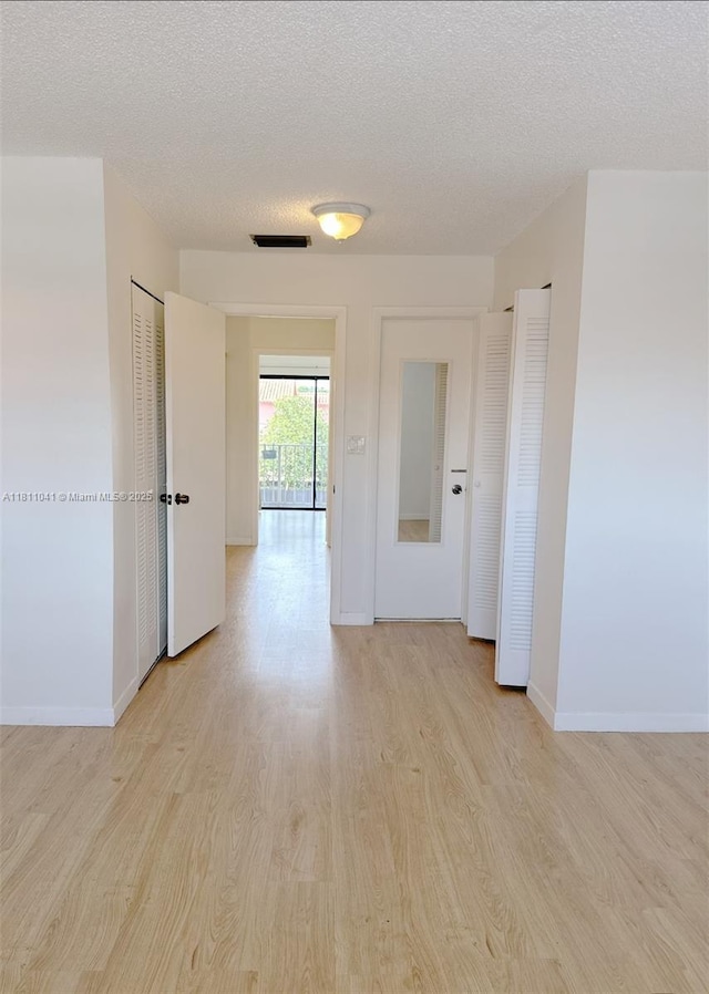550 SW 115th Ave Unit 807D, Sweetwater, FL 33174 - spare room featuring light wood finished floors, a textured ceiling, and baseboards