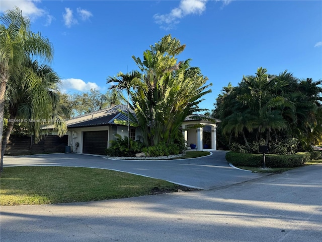 14601 SW 99th Ave, Miami, FL 33176 - obstructed view of property with a garage, driveway, a front lawn, and stucco siding