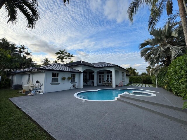14601 SW 99th Ave, Miami, FL 33176 - outdoor pool featuring an in-ground hot tub, a patio, french doors, and central AC unit