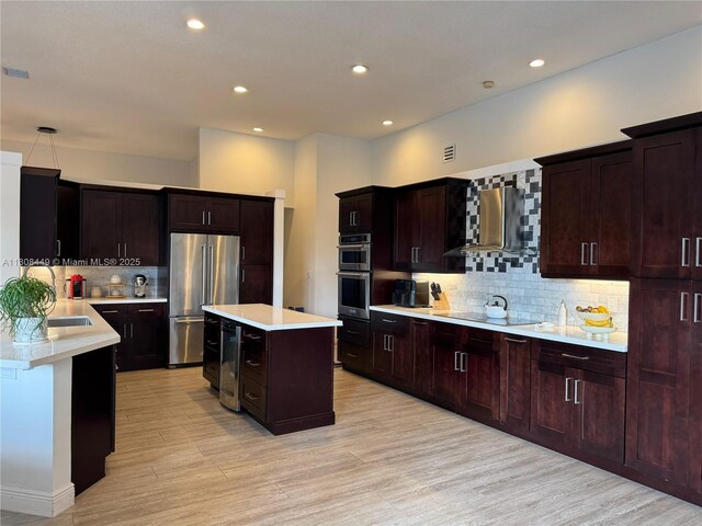 14601 SW 99th Ave, Miami, FL 33176 - kitchen with appliances with stainless steel finishes, wall chimney exhaust hood, light countertops, tasteful backsplash, and light wood-style floors