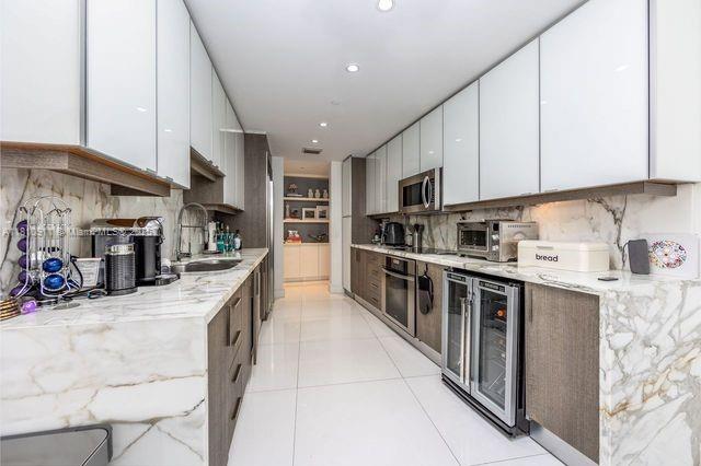 901 Brickell Key Blvd Unit 906, Miami, FL 33131 - kitchen featuring a sink, appliances with stainless steel finishes, wine cooler, modern cabinets, and white cabinetry