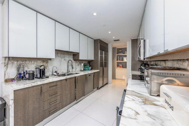 901 Brickell Key Blvd Unit 906, Miami, FL 33131 - kitchen featuring a sink, decorative backsplash, stainless steel appliances, white cabinets, and recessed lighting