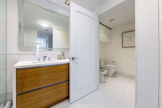 901 Brickell Key Blvd Unit 906, Miami, FL 33131 - bathroom featuring a bidet, vanity, toilet, and tile patterned flooring