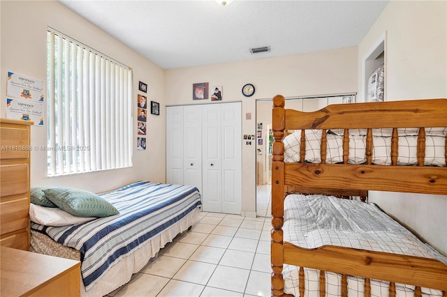 1357 Camellia Ln, Weston, FL 33326 - bedroom featuring light tile patterned floors, a closet, multiple windows, and a textured ceiling